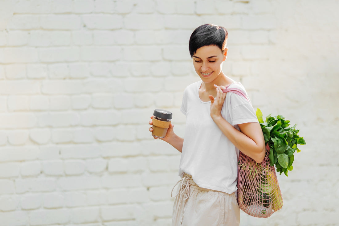 woman reducing her waste by using ways on how to reduce waste like using a reusable coffee mug