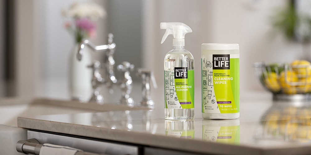 Two bottles of Better Life cleaners sit on a counter in a kitchen.
