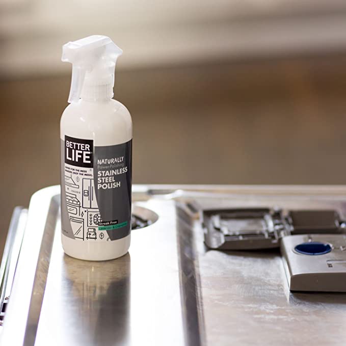 A bottle of Clean Happens Stainless Steel Polish sits on top of a stainless steel counter.