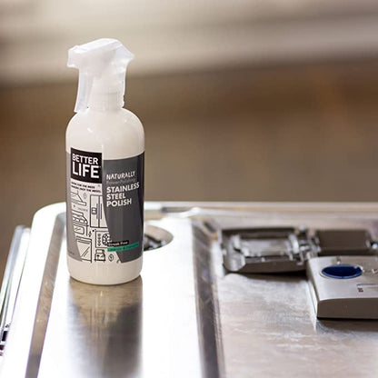 A bottle of Clean Happens Stainless Steel Polish sits on top of a stainless steel counter.