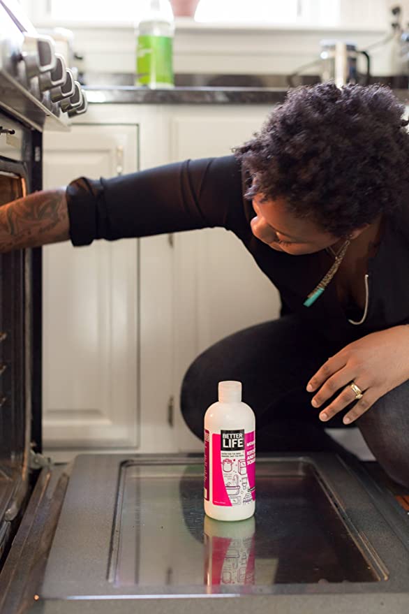 A woman reaching into an oven.