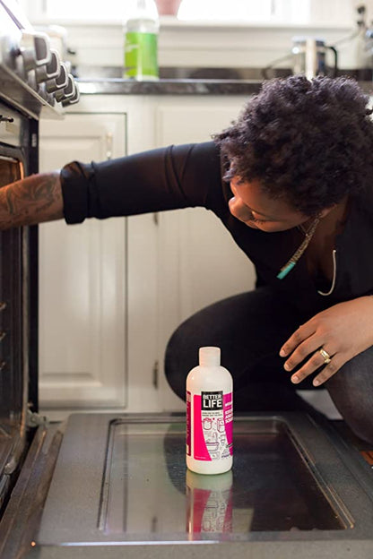 A woman reaching into an oven.
